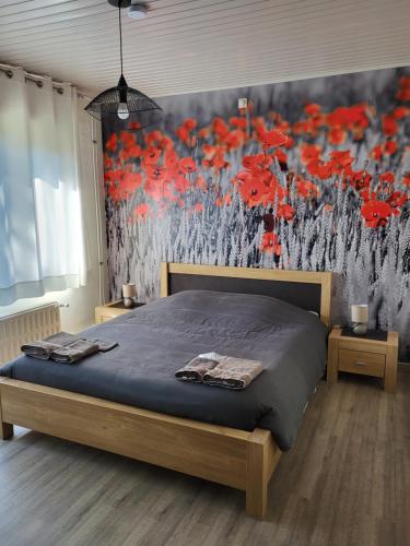 - une chambre avec un lit et une peinture de fleurs rouges dans l'établissement Mary's Poppies - Bed & Breakfast, à Blandain