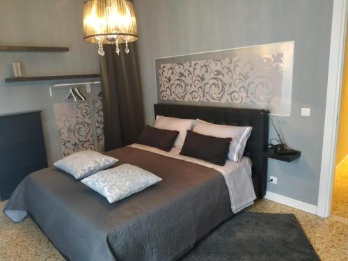 a bedroom with a large bed and a chandelier at Spazio d'arte 372- Three rooms -near the center and train station in Modena