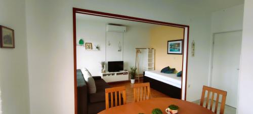 a mirror reflecting a living room with a bed and a table at Apartments Senka in Viganj