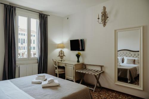 a hotel room with a bed and a mirror at Palazzetto Barnaba in Venice