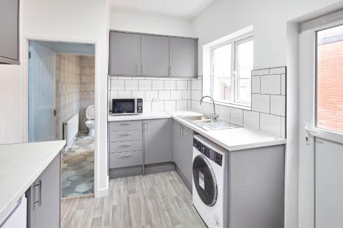a white kitchen with a washer and dryer in it at Host & Stay - 58 Dilston Road in Newcastle upon Tyne