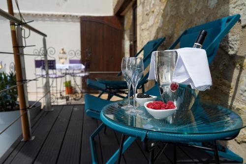 a table with glasses and bowls of fruit on a balcony at LA VILLA in Terraube
