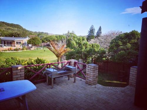 Bushmans River VillageにあるBushmans River Holliday House Retreatのピクニックテーブルとフェンス付きのパティオ