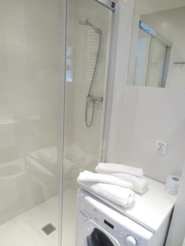 a bathroom with a shower and a sink with towels at Lovely apartment in the heart of the Old Town in Gdańsk