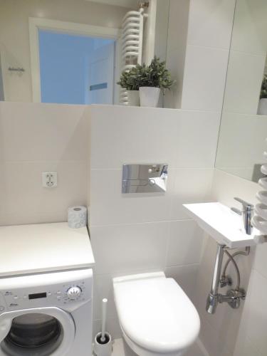 a white bathroom with a toilet and a sink at Lovely apartment in the heart of the Old Town in Gdańsk