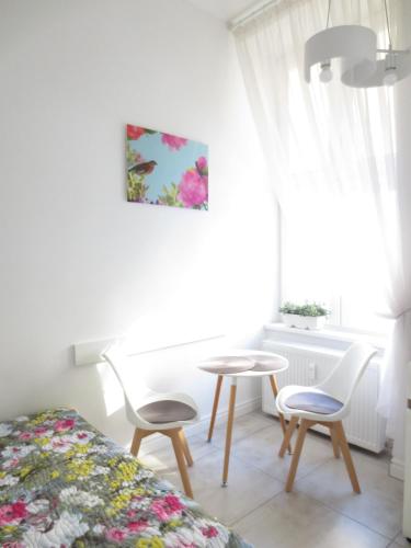 a bedroom with a table and chairs and a window at Lovely apartment in the heart of the Old Town in Gdańsk