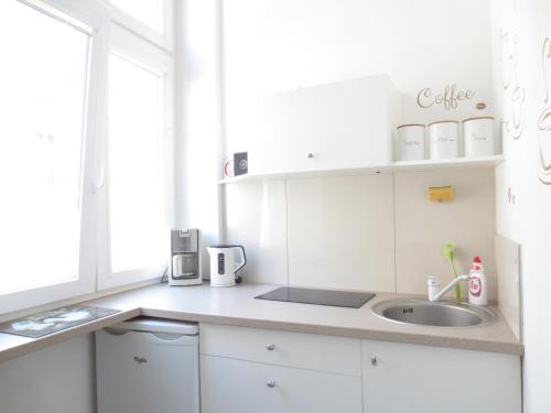 a kitchen with white cabinets and a sink at Lovely apartment in the heart of the Old Town in Gdańsk