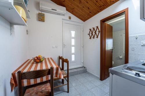 a kitchen with a table with a bowl of fruit on it at Apartmani Mirela in Banjole