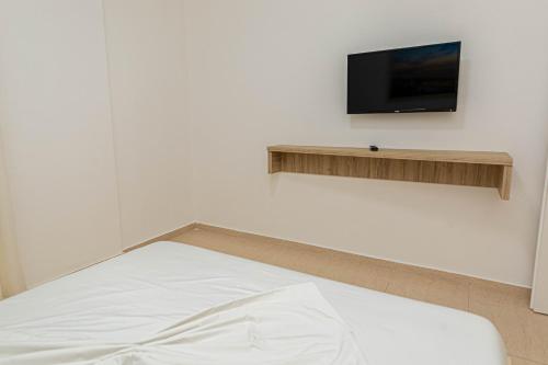 a bedroom with a bed and a tv on a wall at Jordan`s Hotel in Vlorë