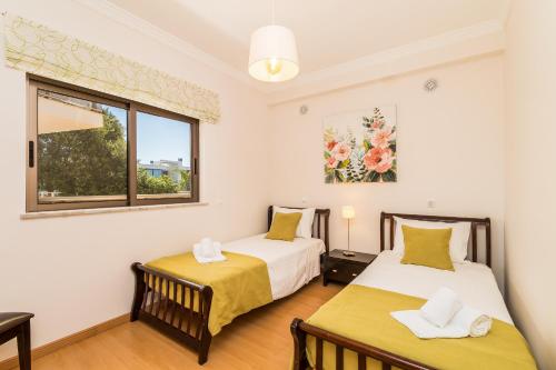 a bedroom with two beds and a window at Vandalou By ALzira in Albufeira