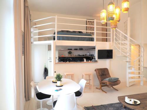 um pequeno apartamento com uma cama alta, uma mesa e cadeiras em Le Bigorneau , beach at 20m and free private carpark em Saint Malo