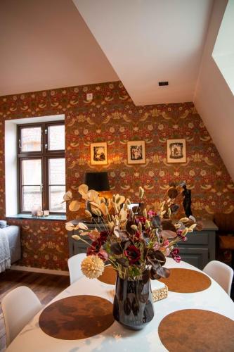 Luxury apartment in Bergen's Gastronomic district في بيرغِن: مزهرية من الزهور على طاولة في غرفة