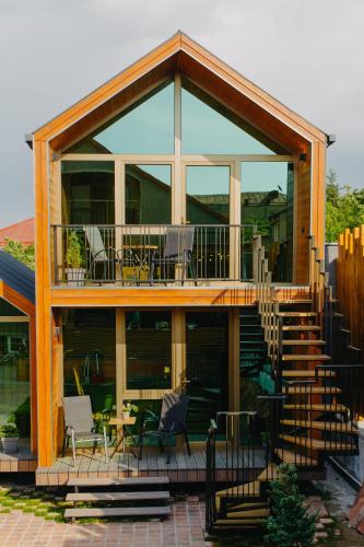 a house with a deck with chairs and tables at wanderholic in Tʼelavi
