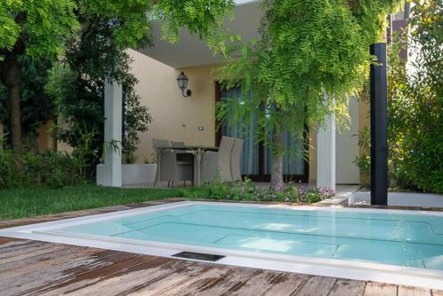 a swimming pool in front of a house at Palazzo della Scala Spa Hotel Suites & Apartments in Lazise