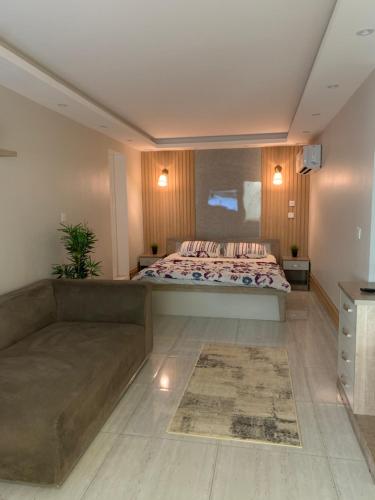 1 dormitorio grande con 1 cama y 1 sofá en شالية فاخر بمسبح خاص بمكة المكرمة en Makkah