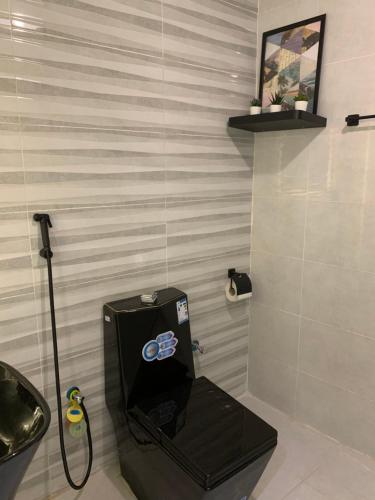 a bathroom with a black toilet and a sink at شالية فاخر بمسبح خاص بمكة المكرمة in Makkah