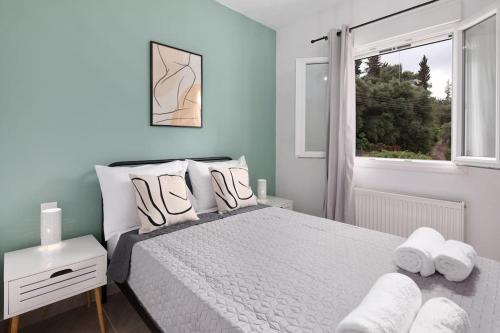 a bedroom with a bed with white pillows and a window at Summer Moments Pool Villa in Evropoúloi