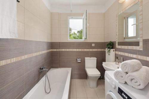 ein Badezimmer mit einer Badewanne, einem WC und einem Waschbecken in der Unterkunft Summer Moments Pool Villa in Evropoúloi