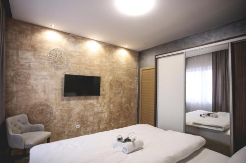 een hotelkamer met 2 bedden en een televisie bij VILA MB in Ruma