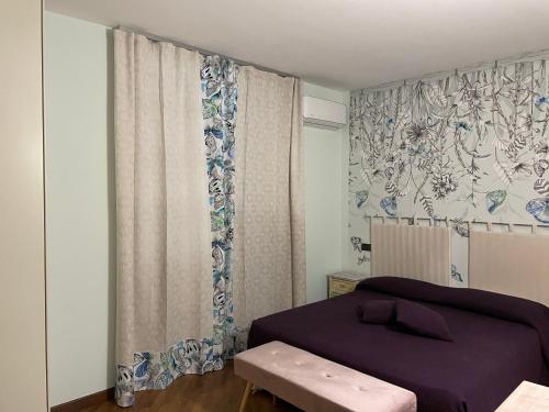 アルバにあるLa Maison du Soleil Appartamento Alba Pompeiaのベッドルーム1室(ベッド1台付)、窓(カーテン付)