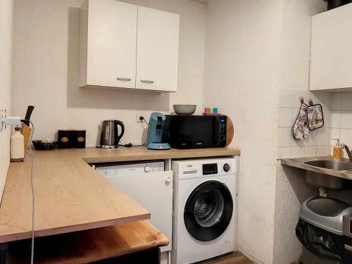 eine Küche mit einer Waschmaschine und einer Mikrowelle in der Unterkunft Plein centre ville Appartement in Salon-de-Provence