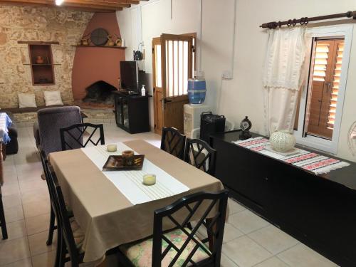 a dining room with a table and chairs and a kitchen at Friendly villagehouse in Paphos