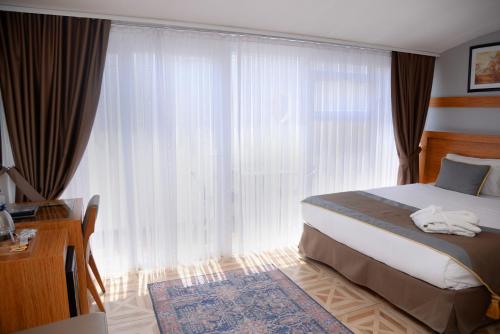 a bedroom with a bed and a large window at Edibe Sultan Hotel in Istanbul