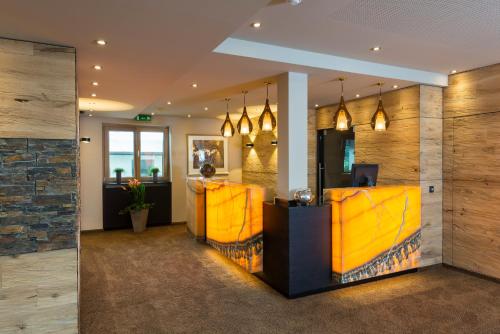 a lobby with a bar with yellow walls at Aparthotel Bergland in Söll