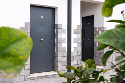 two black doors on a house with plants at Stella Marina - Camere e Monolocali Turistici in Monte San Biagio