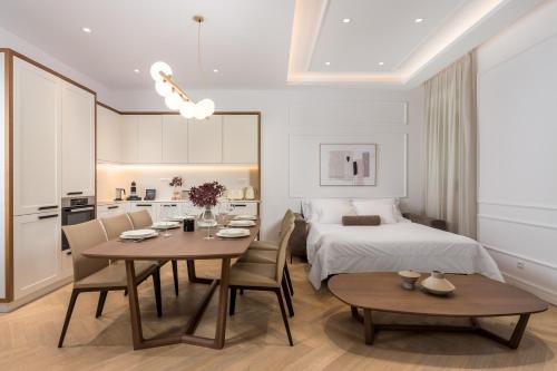 a room with a bed and a table and chairs at Plaza Apartments in Opatija