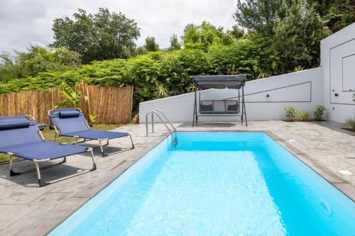 a swimming pool with two chairs and a table and a pool at Summer Stories Pool Villa in Potamós