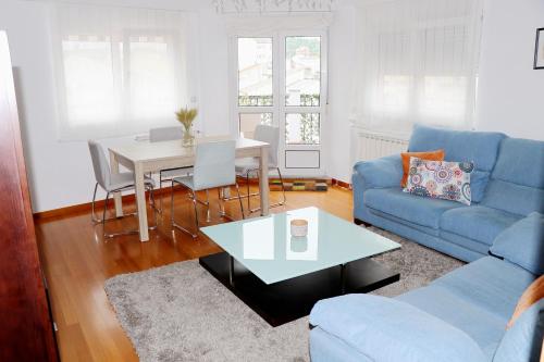 sala de estar con sofá azul y mesa en ÁTICO DUPLEX CREDENCIAL, en Sarria