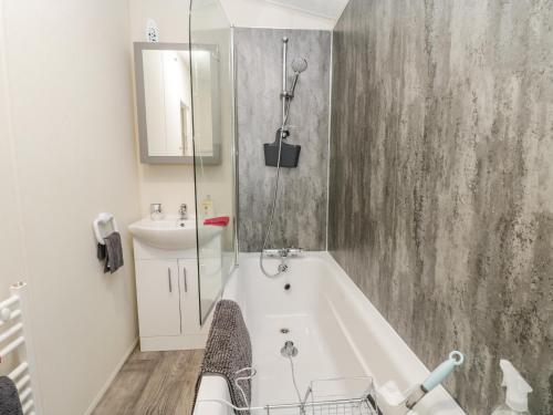 a bathroom with a bath tub and a sink at Happy Daze in Bridlington