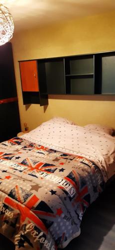 Una cama con un edredón colorido en un dormitorio en Guiguitte en La Chapelle-lès-Luxeuil