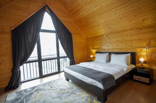 a bedroom with a bed and a large window at Everest Rest House in Tsaghkadzor