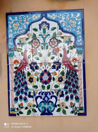 a mosaic tile with two birds on a wall at La sinfonia di.kerkent in Agrigento