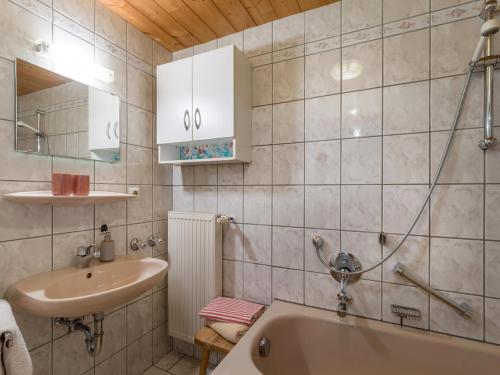 a bathroom with a sink and a bath tub at Gästehaus Gerti in Kiefersfelden