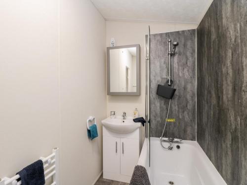 a bathroom with a tub and a sink and a mirror at Lazy Daze in Bridlington