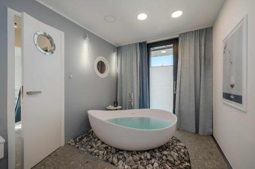 łazienka z dużą wanną i prysznicem w obiekcie Stormy w mieście Lubmin