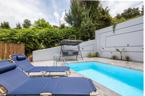 uma piscina com duas cadeiras e uma mesa de bilhar azul em Summer Stories Pool Villa em Potamós