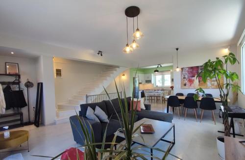 sala de estar con sofá azul y escalera en The Bright House a two-storey maisonette in Loutraki, en Loutraki