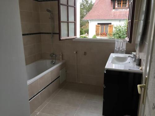 a bathroom with a tub and a sink and a bath tub at Villa Bonaparte in Touques