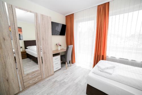 een slaapkamer met een spiegel, een bed en een bureau bij Othman Appartements Anderter Straße 55a 1OG in Hannover