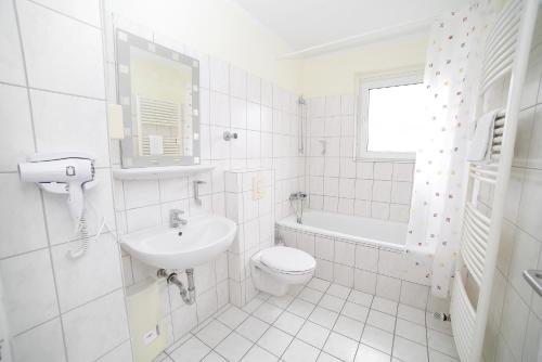 een witte badkamer met een wastafel en een toilet bij Othman Appartements Anderter Straße 55a 1OG in Hannover