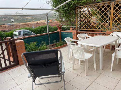 a patio with a white table and chairs and a white table and chairs at Accogliente Appartamento Costa Makauda in Ribera