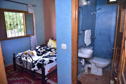 1 dormitorio con cama con estampado de vaca y lavamanos en IMLIL VALLEY Garden en Imlil