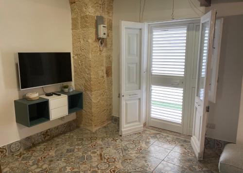 a living room with a flat screen tv on a wall at Casa Stella Salento - grazioso appartamento con 2 camere da letto nel cuore di Galatone in Galatone