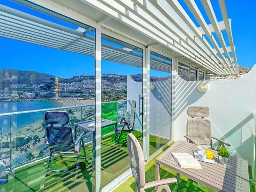 a balcony with a table and chairs and a view of the city at Punta Del Rey Only Adults in Puerto Rico de Gran Canaria