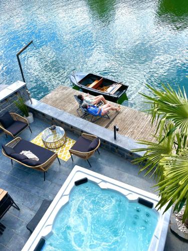 a man laying in a boat next to a swimming pool at Gatsby River I in Yvoir