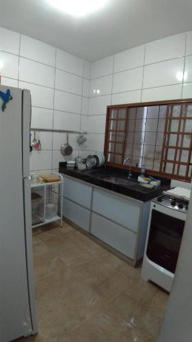 a kitchen with a sink and a refrigerator at Hostel Miscelânea in Sete Lagoas